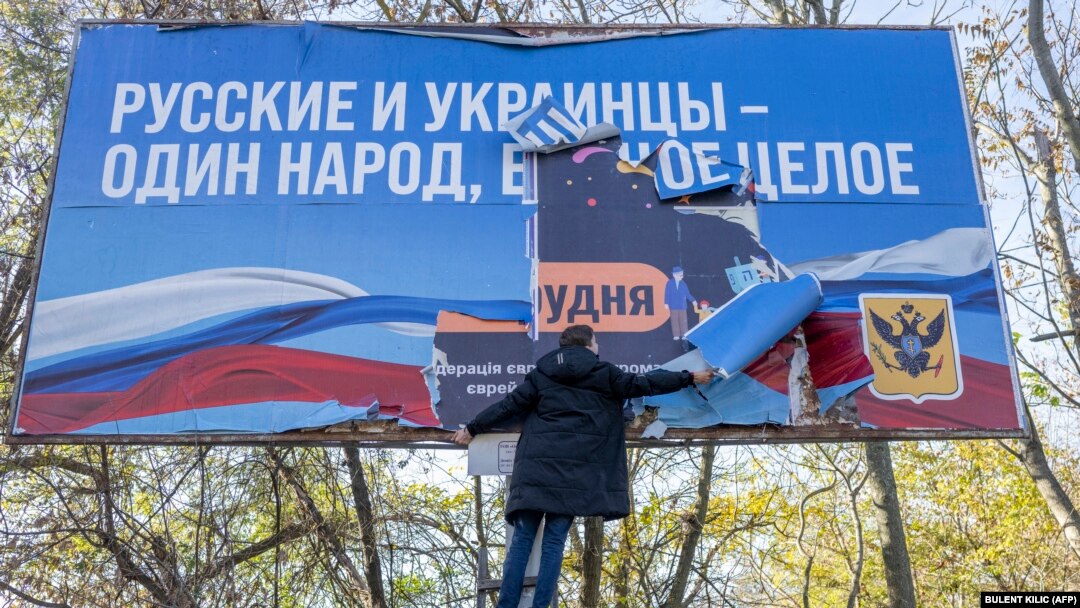 ЗСУ можуть повернути Крим під контроль України вже до кінця цього року. На фото: чоловік знімає російський банер у щойно звільненому Херсоні, 14 листопада 2022 року