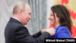 Президент Росії Володимир Путін і головний редактор телеканалу RT і державного інформаційного агентства «Росія сьогодні» Маргарита Симоньян, нагороджена орденом Олександра Невського. Кремль, Москва, 23 травня 2019 року
