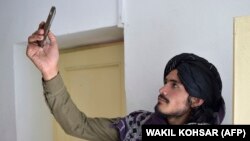 یکی از افراد طالبان در حال استفاده از تلفن همراه
