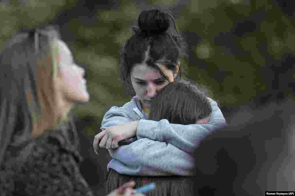 Evacuated residents embrace each other as they wait outside.
