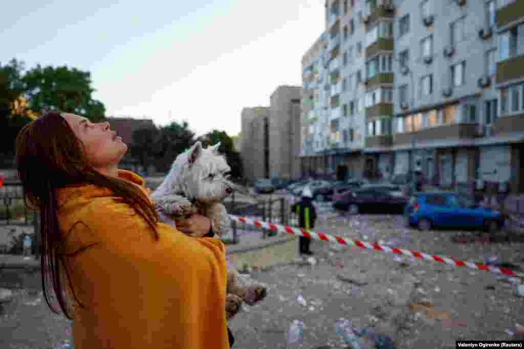 A woman looks at her apartment building, which was damaged in the early morning drone strike. The Ukrainian military said the attack solely consisted of Iranian-made drones and lasted from shortly before midnight until 4:30 a.m.