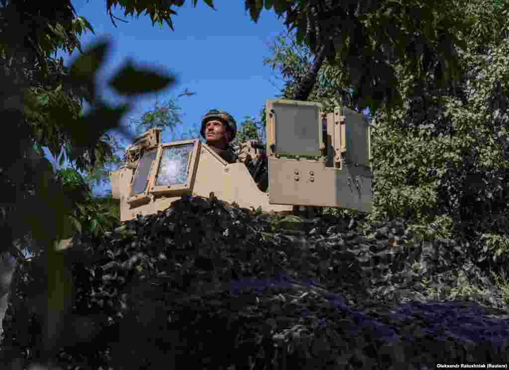 A camouflaged Ukrainian air-defense unit hidden among the trees keeps watch. 