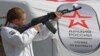 Агітаційниця тримає макет автомата АК-74 на мобільному пункті вербування у лави російської армії в окупованому Росією Сімферополі. Окупований Крим, 15 квітня 2023 року