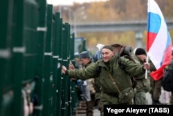 A mobilized Russian man holds a Russian flag at an assembly station at the Kazan Expo International Exhibition Center on October 23, ahead of departing for the front lines in Moscow's invasion of Ukraine.