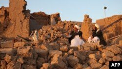 تخریبات ناشی از زلزله در هرات. دو تن از روستاییان که خانه های شان ویران شده است روی مخروبه ها نشسته اند