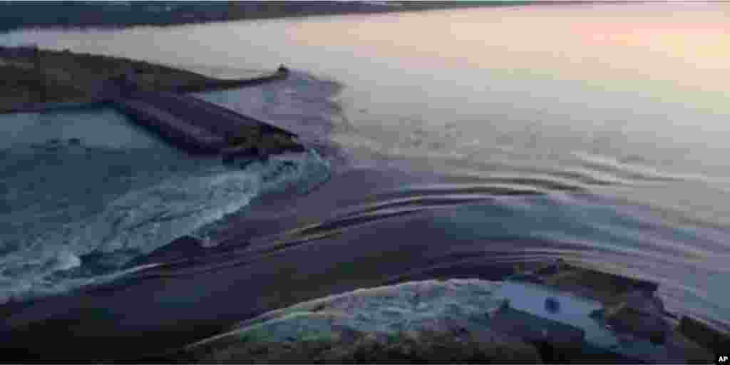 Drone footage captures water as it runs through a breakthrough in the Kakhovka dam on June 6. Kyiv accused Russian forces of blowing up the dam and called it a form of "ecocide." 