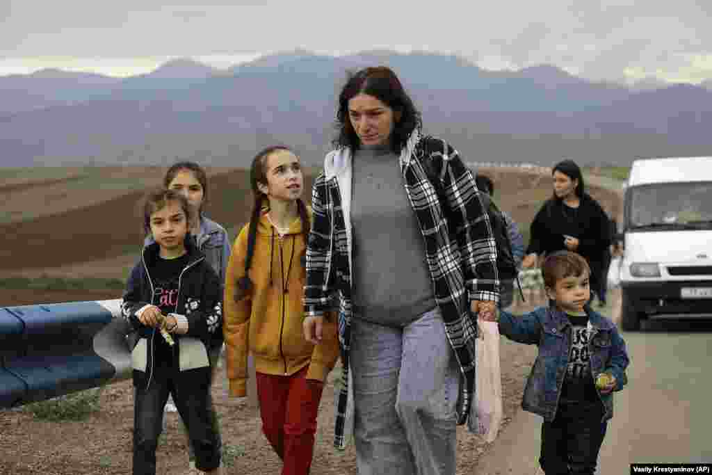 Refugees walk along the road from Nagorno-Karabakh to Kornidzor in Armenia on September 26 amid a massive exodus that followed an Azerbaijani offensive, which gave Baku complete control of the mountainous region.