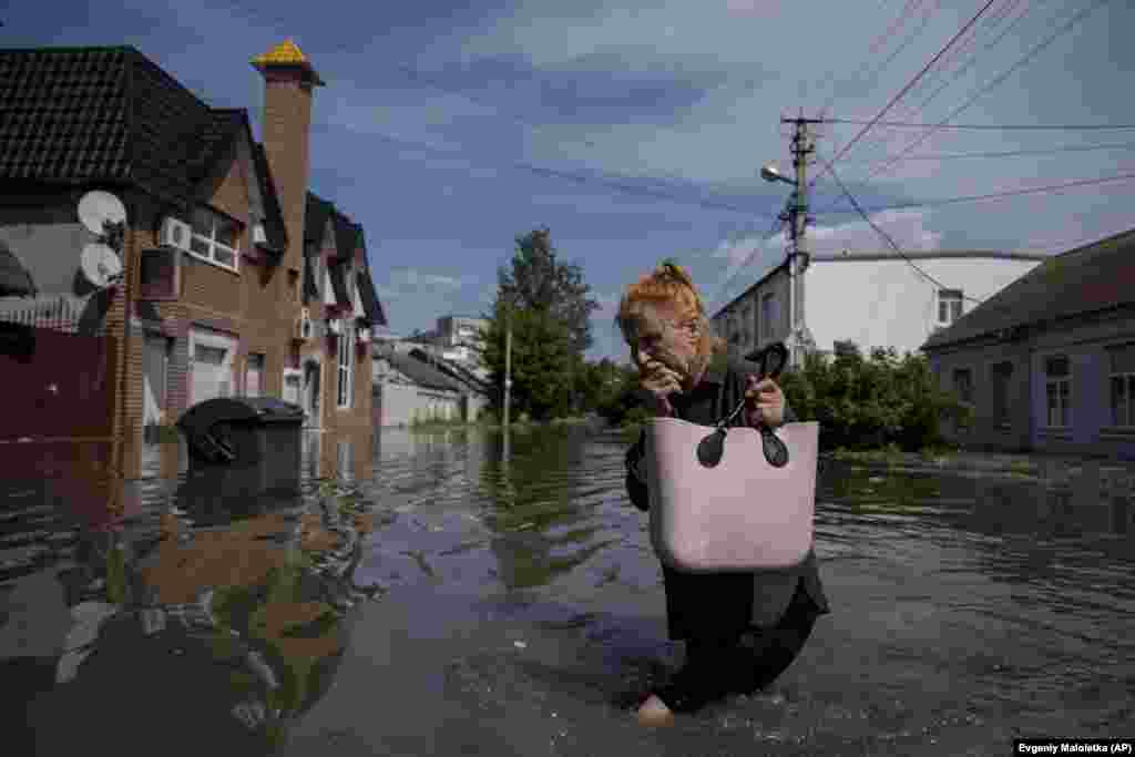 A woman makes her way through a flooded road in Kherson. The city, which had a prewar population of nearly 300,000 people, is now facing a new humanitarian disaster. Much of Kherson's infrastructure was destroyed during an eight-month Russian occupation. 