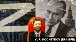 Російська матрьошка з портретом голови Китаю Сі Цзіньпіна перед фотографією очільника Росії Володимира Путіна у сувенірній вуличній крамниці в центрі Москви, 20 березня 2023 року (ілюстраційна світлина)