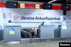Співробітник сидить за столом у центрі розміщення біженців, у тому числі українців, у колишньому аеропорту Тегель у Берліні, Німеччина, 9 листопада 2022 року