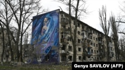 Архівна світлина. Мурал із зображенням жінки з дитиною на стіні сильно пошкодженого внаслідок обстрілів армією РФ житлового будинку в прифронтовому місті Авдіївці на Донеччині, 4 квітня 2023 року