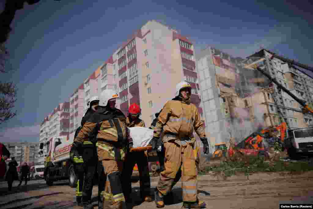 Rescuers remove the body of one of those killed in Uman in the early morning attack. The Ukrainian capital, Kyiv, was also rocked by explosions. Officials reported that air-defense units shot down 11 missiles and two drones.