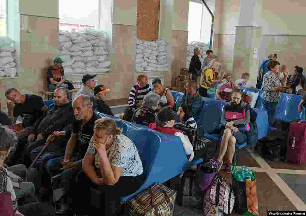 Residents wait for an evacuation train at the railway station in Kherson. Russia said Ukraine had carried out "deliberate sabotage" on the dam at Nova Kakhovka. It was not possible to independently verify what happened. 
