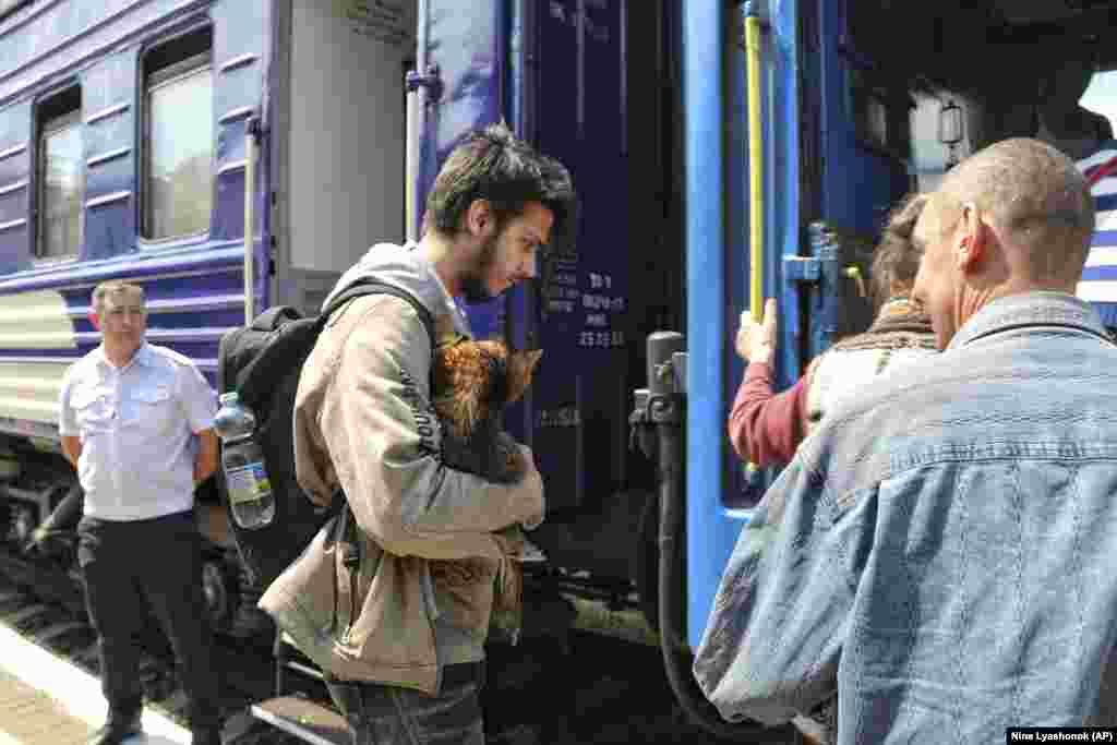People board an evacuation train at the railway station in Kherson. 
