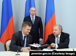 Володимир Путін на підписанні угоди про стратегічну співпрацю між тодішнім керівником «Роснафти» Едуардом Худайнатовим (праворуч) та представником норвезької компанії. 5 травня 2012 року
