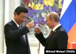 Голова КНР Сі Цзіньпін (ліворуч) і президент Росії Володимир Путін після підписання спільних документів. Китай, 21 травня 2014 року