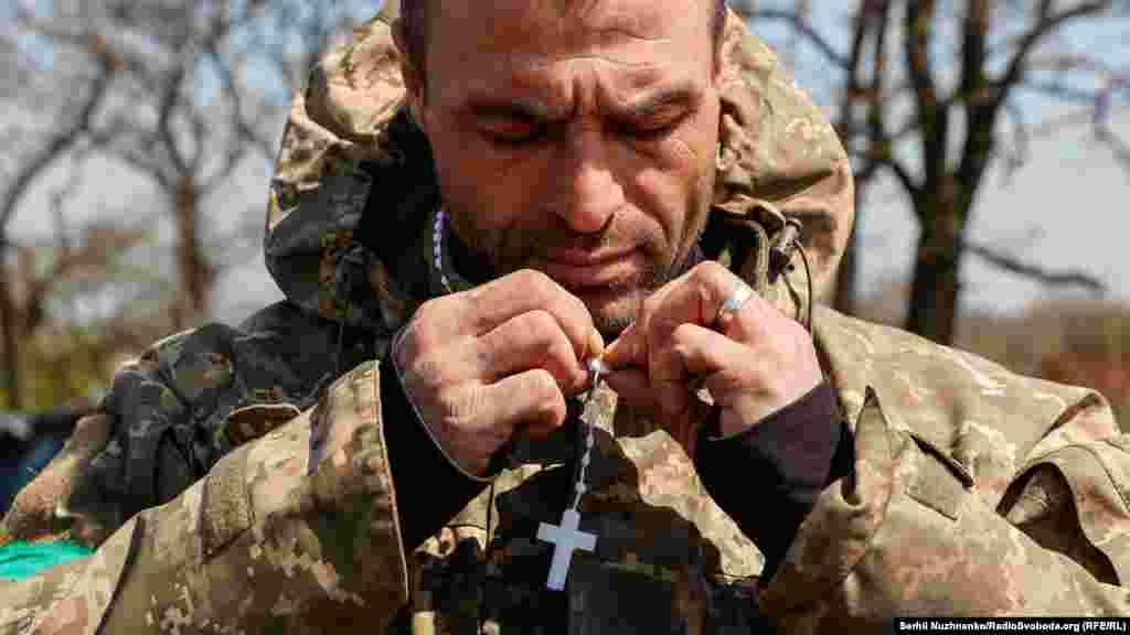 Український військовий ховає вервицю, подаровану військовими капеланами. Харківська область, Україна, 24 квітня 2022 року