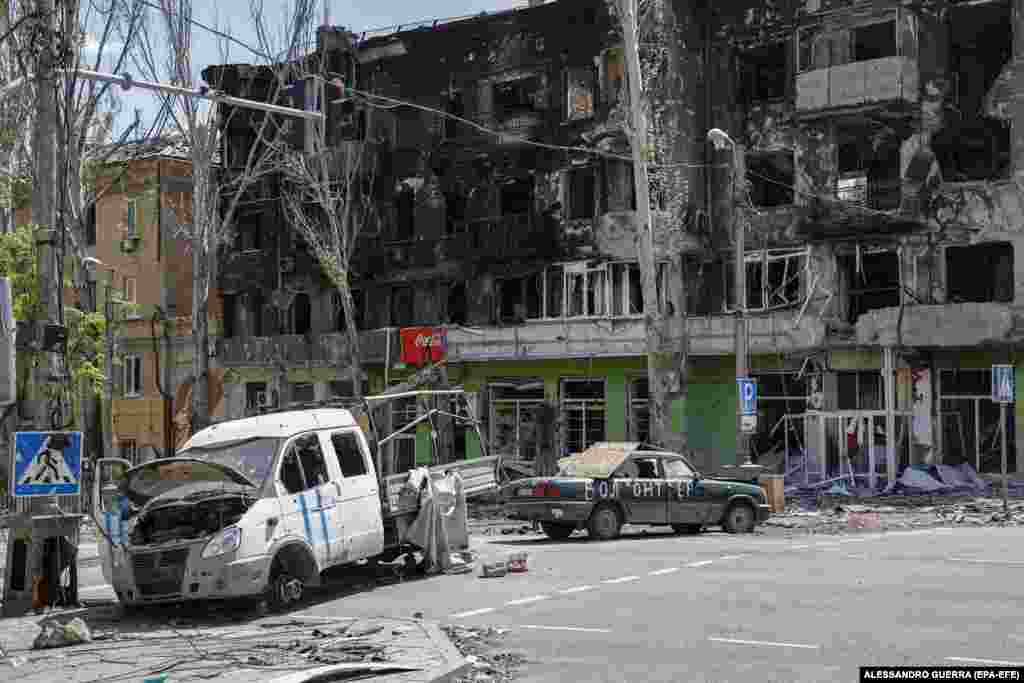 Destroyed cars block a street near the celebrations in Mariupol.&nbsp;