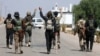 Bedouin fighters gather in the village of Busra al-Harir, northwest of Sweida city, while security forces cordon off the area in southern Syria on July 22.