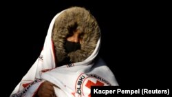A migrant from Somalia covers herself with a blanket after crossing the Belarusian-Polish border in Siemianowka, Poland, on October 25.