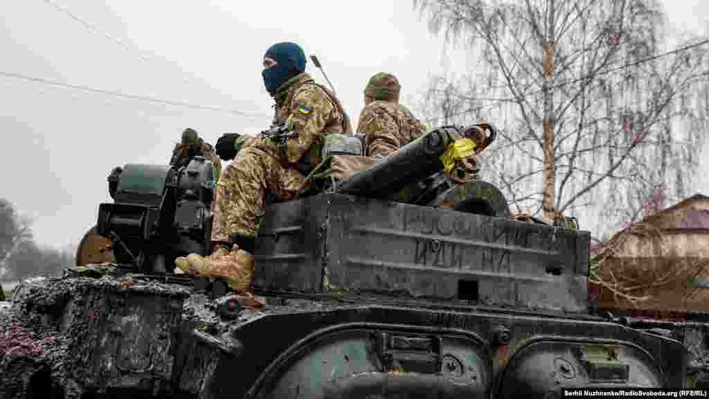 Ukrainian soldiers patrol the streets of the shattered village.
