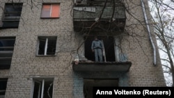 Ілюстраційне фото: місцевий житель Олександр Антоненко стоїть на балконі своєї квартири в будинку, пошкодженому російським обстрілом, Херсон, 27 листопада