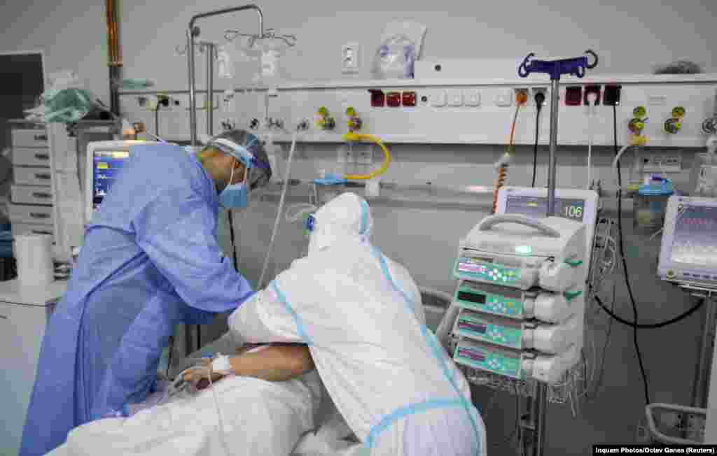 Staff of the Marius Nasta Pneumology Institute in Bucharest adjust a breathing mask on a coronavirus patient's face on October 17. Romania's president said on October 19 the crisis in Romania's overflowing hospitals was a "national drama of terrible proportions," blaming low vaccination rates among the Romanian population and a sluggish response from the authorities for the soaring coronavirus infection rates. 