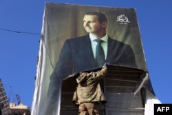 Антиурядовий боєць зриває портрет президента Сирії Башара Асада в Алеппо після того, як джихадисти та їхні союзники увійшли до північного сирійського міста, 30 листопада 2024 року