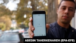 Iranac pokazuje svoj telefon na kojem ne može da učita stranicu s društvenih mreža. Vlasti blokiraju desetine hiljada sajtova i redovno guše ili prekidaju internet veze.