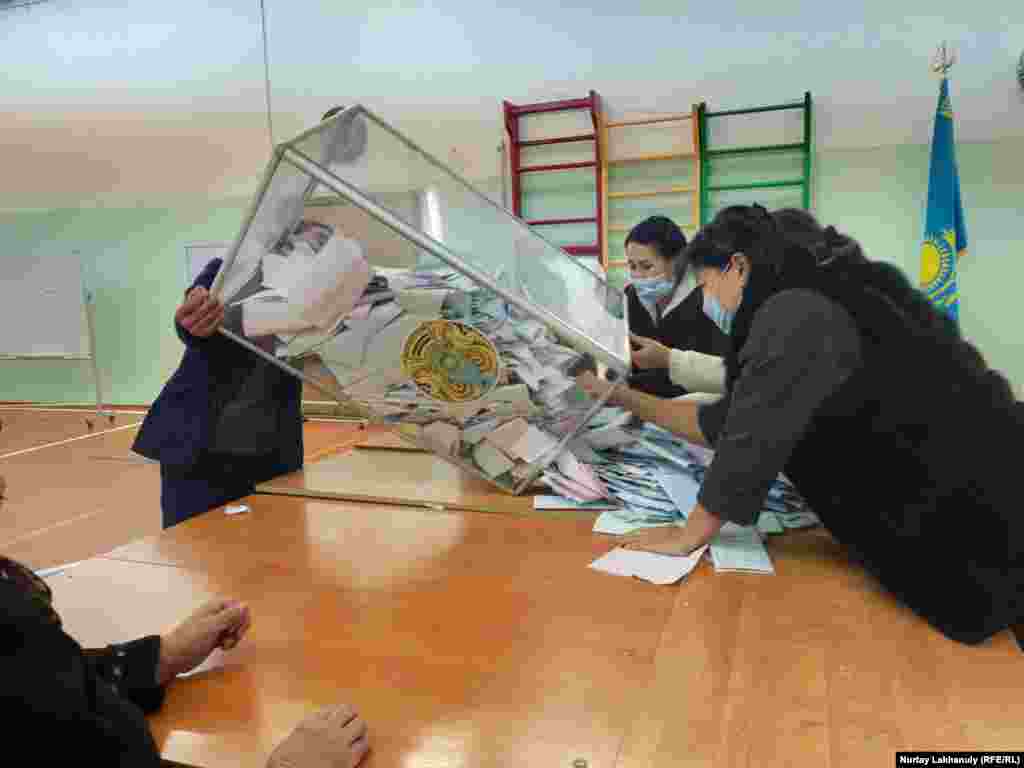 Members of a local election commission empty a ballot box ahead of counting votes after the elections in the village of Zhalgamys in the Almaty region on January 10.