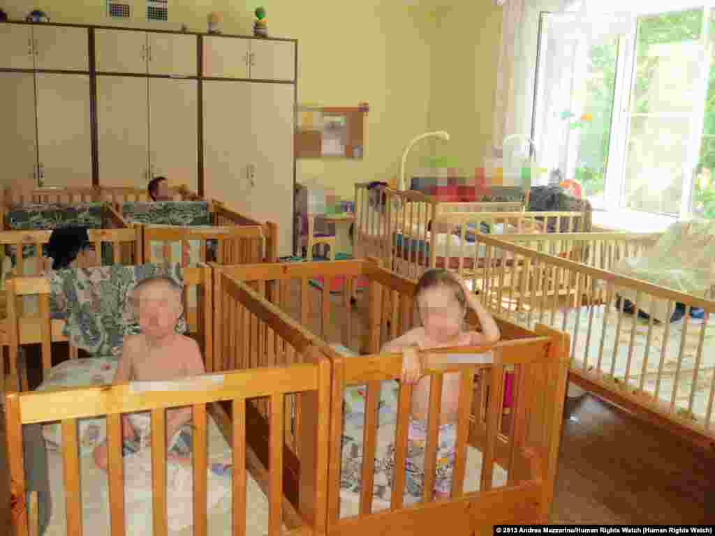 Roman K., 18, (left) and Lyuba P., 15, in a &quot;lying-down&quot; ward of an orphanage for children with disabilities in northwest Russia. Roman K. was awaiting transfer to an institution for adults with disabilities. A pediatrician specializing in the health of children with disabilities told Human Rights Watch that, based on photographs, both Roman K. and Lyuba P. appeared significantly underdeveloped for their ages, a possible result of lack of adequate nutrition, stimulation, and health care.