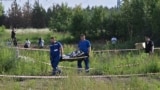 Сотрудники российских правоохранительных органов несут тело бывшего министра транспорта Романа Старовойта, который был найден мертвым от огнестрельного ранения через несколько часов после своей отставки в Одинцово под Москвой 7 июля