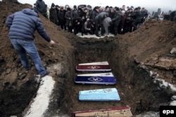 Relatives and friends attend the funerals for Nikolay and Lyubov Bobilev, their daughter Marina Kashina, and their 3-year-old grandson Vyacheslav, who were killed during the January 24 shelling of Mariupol.