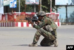 An Afghan National Army commando aims his weapon amid ongoing fighting between Taliban militants and Afghan security forces in Kunduz on October 5.