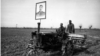 Постер од советскиот лидер Јосиф Сталин на еден од првите трактори фотографирани на работа на полињата во Узбекистан.<br>На почетокот на 1925 година, регионот на денешен Узбекистан беше прогласен за република на Советскиот Сојуз. Советското преземање означи период на сурова трансформација, што вклучуваше егзекуции на узбекистански политички затвореници, како и програми за писменост и индустријализација.
