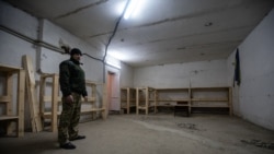 Дмитро Кондратьєв показує процес облаштування бомбосховища, куди під час артобстрілу приходили люди