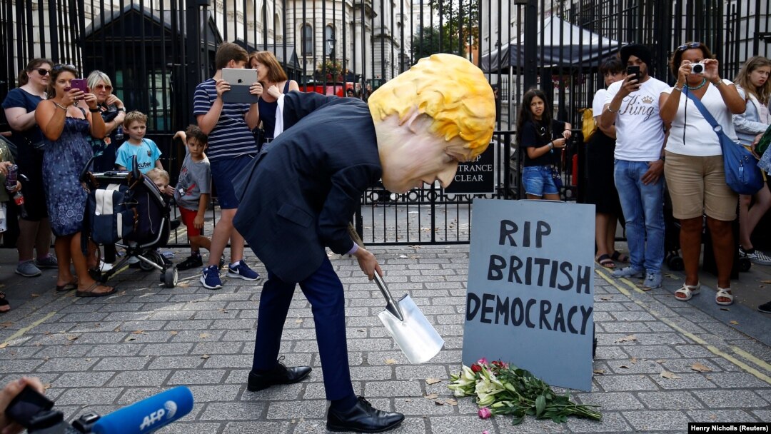 Demonstrant sa maskom britanskog premijera ispred njegove rezidencije u Downing Streetu u Londonu
