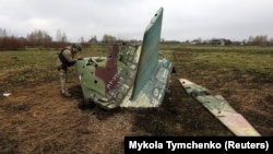 Український військовий сапер оглядає останки російського бойового літака Су-25, збитого ЗСУ на Київщині, 21 квітня 2022 року
