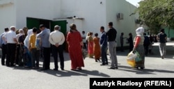 Long lines of people wait in front of a grocery store in Ashgabat to buy vegetable oil, sugar, and flour in late May.
