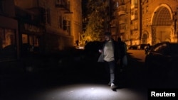 Чоловік йде темною вулицею під час часткового відключення електроенергії у Києві, Україна, 16 травня 2024 року
