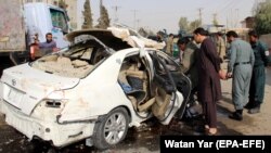 Afghan security officials inspect the scene of a IED blast in Helmand on November 12, 2020, that killed Radio Free Afghanistan journalist Mohammad Ilyas Dayee. 