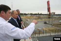 Russian President Vladimir Putin (second from left) listens to Roskosmos chief Oleg Ostapenko during a visit to the Vostochny Cosmodrome in September 2014.