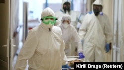 Medical specialists wearing protective gear transport a patient at City Clinical Hospital No. 1, where people suffering from COVID-19 are treated, in Volzhsky, Russia, on October 25.