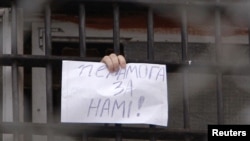 A Belarusian detainee arrested during the postelection protests flashes a sign from his prison cell in Minsk on December 23 that reads, "Victory is with us."