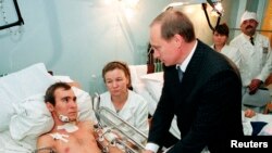 На той час прем’єр-міністр Росії Володимир Путін (справа) розмовляє з російським солдатом, пораненим у Чечні (зліва), а його мати (друга зліва) сидить біля його ліжка у військовому шпиталі під Москвою, 28 грудня 1999 року