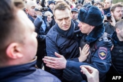 Police officers detain Kremlin critic Aleksei Navalny (center) during an anticorruption rally in central Moscow on March 26.