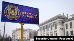 Білборд із емблемою контррозвідки СБУ і написом, що Крим – це Україна, який встановлений перед посольством Росії в Україні. Київ, 2021 рік