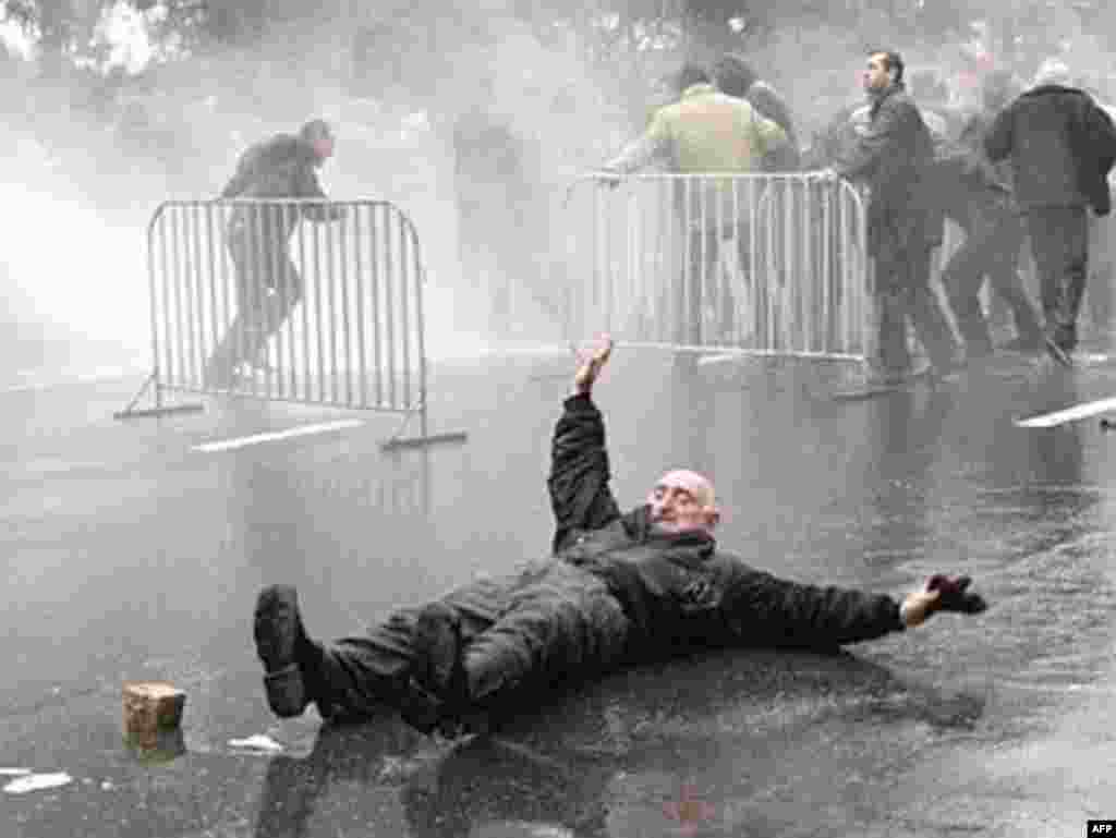 A Georgian opposition supporter falls down as special police forces use water to disperse protesters in front of the parliament building in Tbilisi on November 7, 2007. (AFP photo)