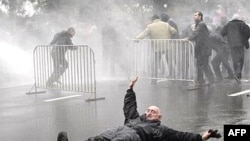 An opposition supporter falls down as police dispersed opposition protesters in last year's violence