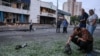 A man inspects a piece of engine after a night of Russian drone strikes in Kyiv on July 20-21. In the background is an entrance to the Lukyanivska subway station.